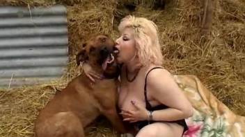 Sensual mature blonde fucks with a big trained doggy at the hayloft