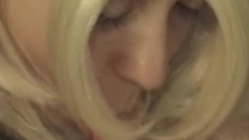 Teen blonde girl in a wig is sucking dog's cock